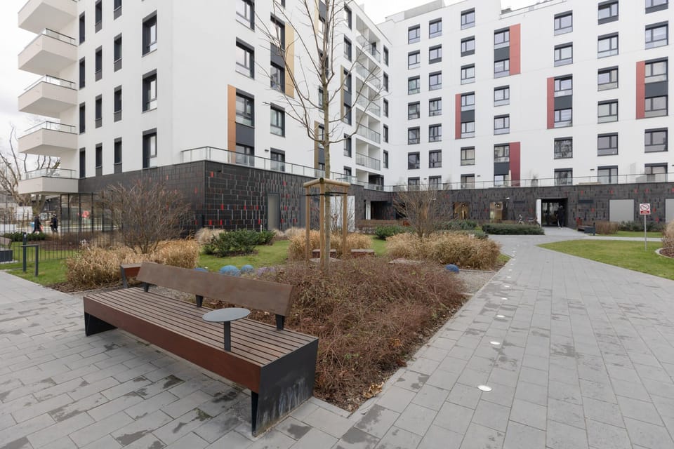 An inviting courtyard with benches and greenery, offering a peaceful outdoor space.

