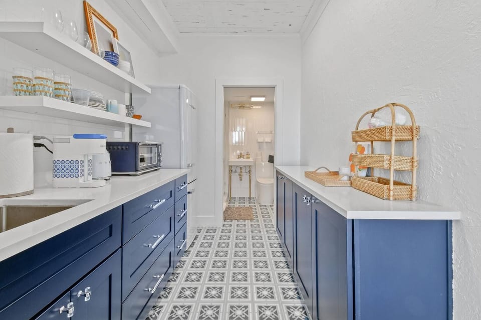 Large, fully stocked kitchenette with microwave, fridge, Keurig coffee maker, glasses, plates, and cutlery
