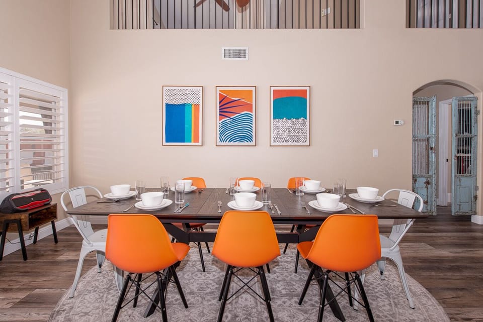 Dining room with desert mid-century modern decor has views of pool. Goodyear, AZ