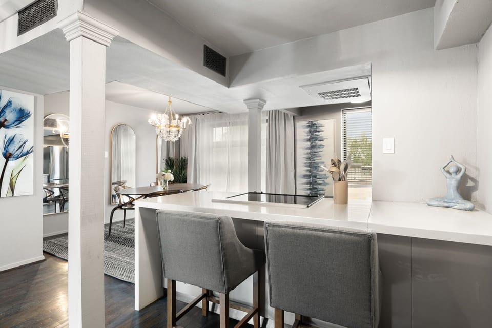 Open dining area with seating for four, highlighted by a beautiful chandelier and a stylish buffet, perfect for both entertaining and additional storage.