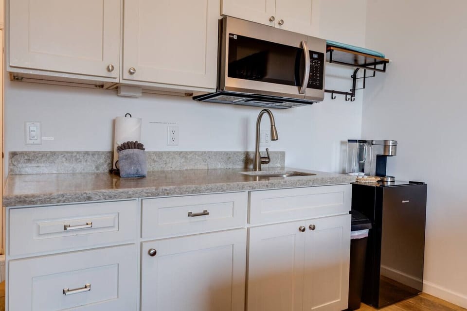 Kitchenette equipped with essential tools for preparing small meals. There is no stove or oven, but it includes a portable hot plate, skillet, and other basic cookware