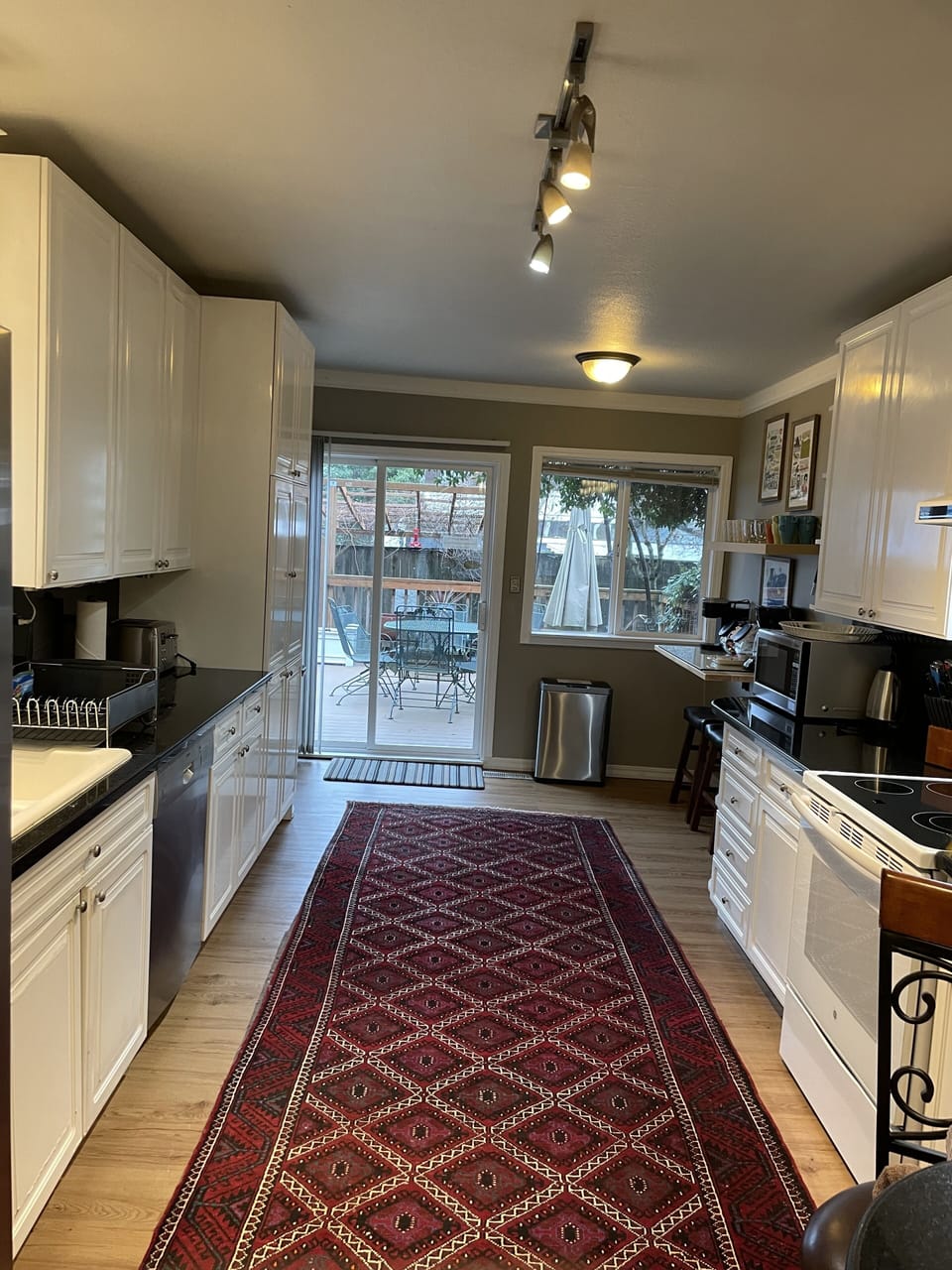 Kitchen leading to deck with a BBQ . A coffee station at the of the kitchen.