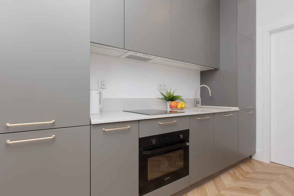 A modern kitchen with sleek gray cabinets and integrated appliances.

