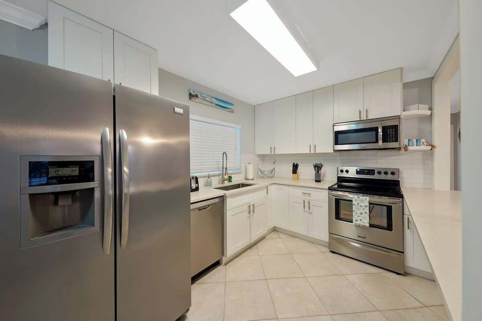 Kitchen is equipped with essentials. It has refrigerator, stove, oven, microwave, storage space, pans, pots and dish ware. 