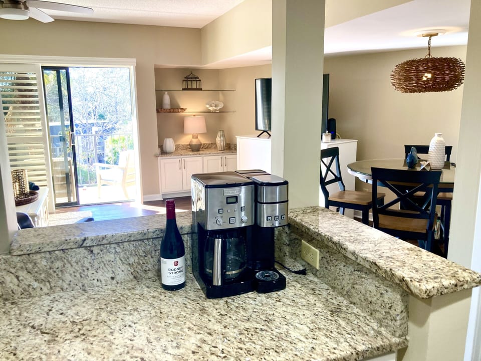 Kitchen bar is open to the dining table and den.