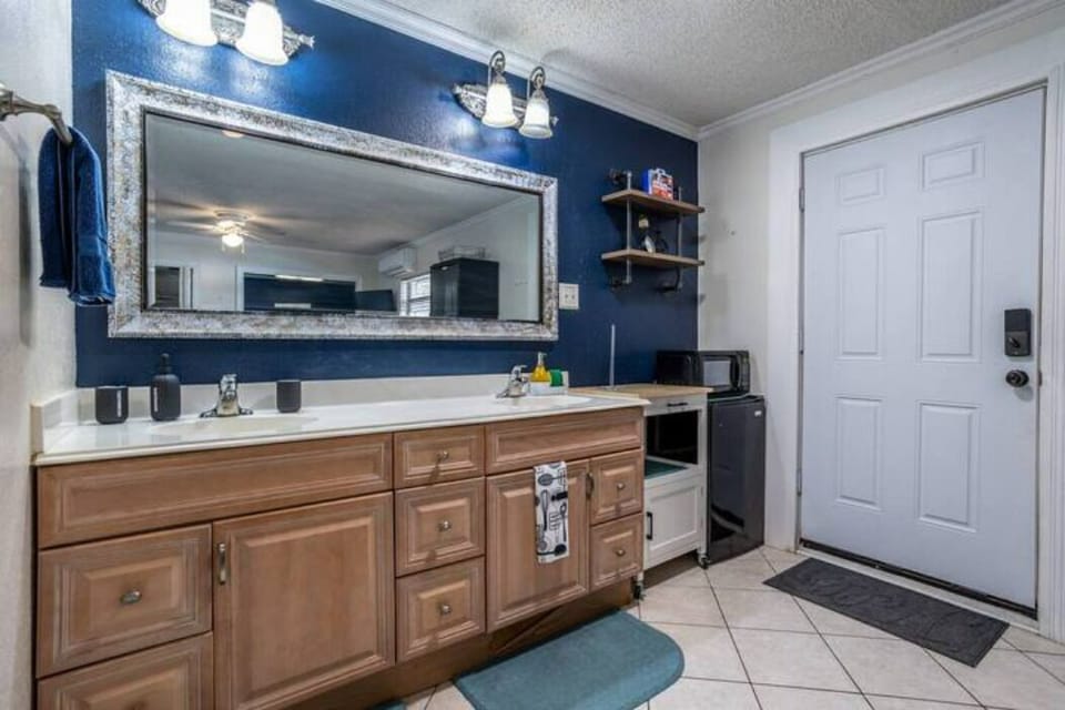 Kitchen with a microwave, small fridge, two-burner stove, and a cabinet for dishes.