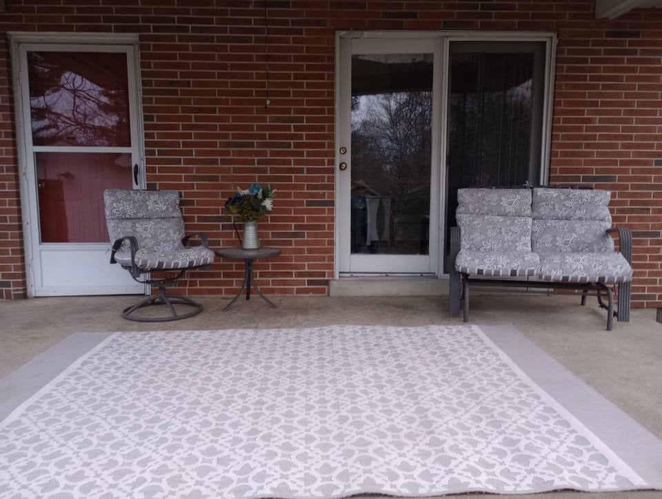 back porch with lawn and semi wooded view
