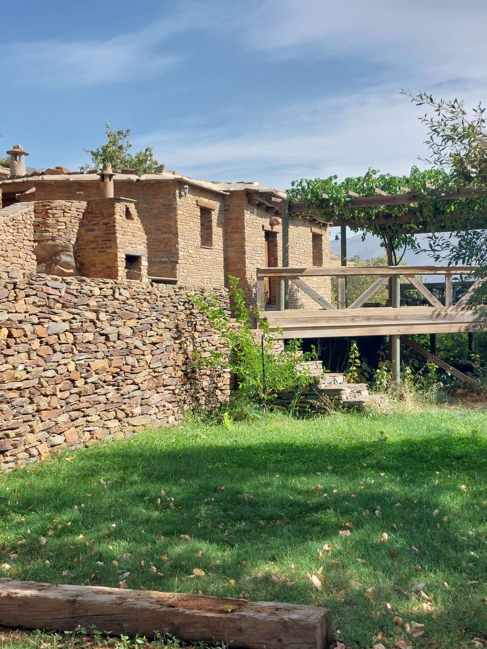 View of outside of Walnut cortijo with wooden terrace, Cortijos Rey Fini.