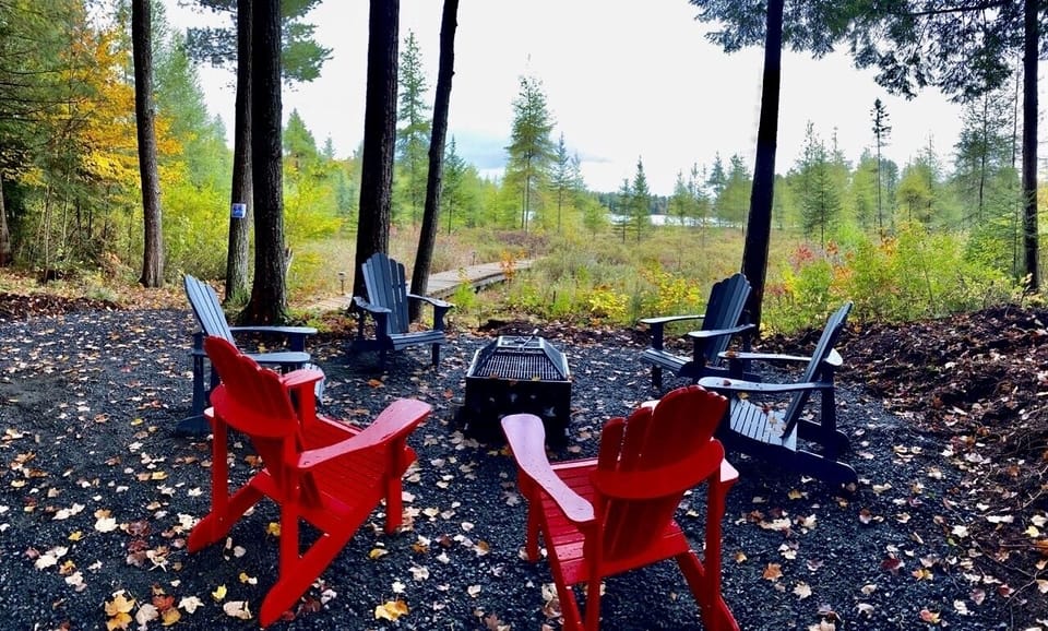 Fire pit are with Muskoka chairs overlooking the lake