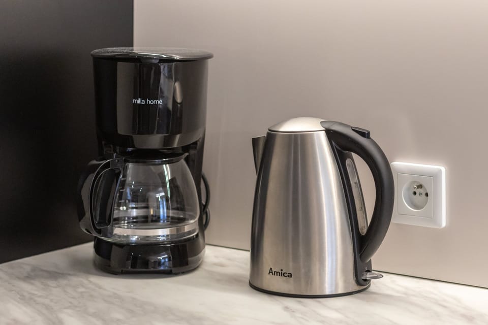 A coffee station with a coffee maker and electric kettle, ensuring guest convenience.
