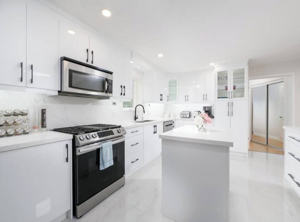 Kitchen with gas stove, microwave, and exit to the second floor BBQ balcony. 