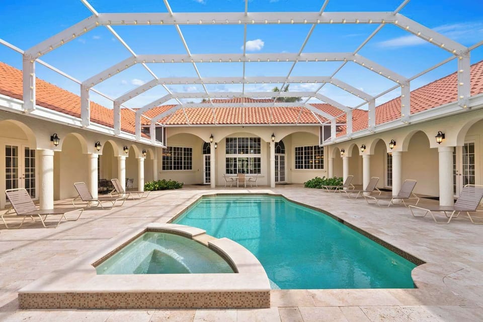 Outdoor area with heated pool and hot tub