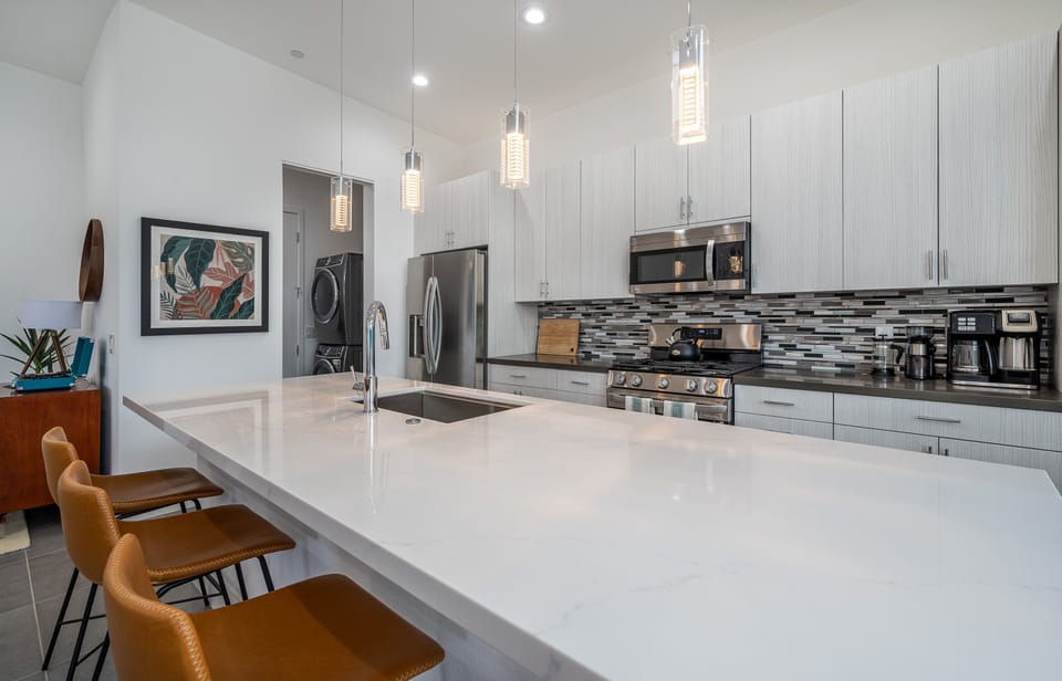 Well-equipped kitchen with gas stove, single-basin sink, and microwave.