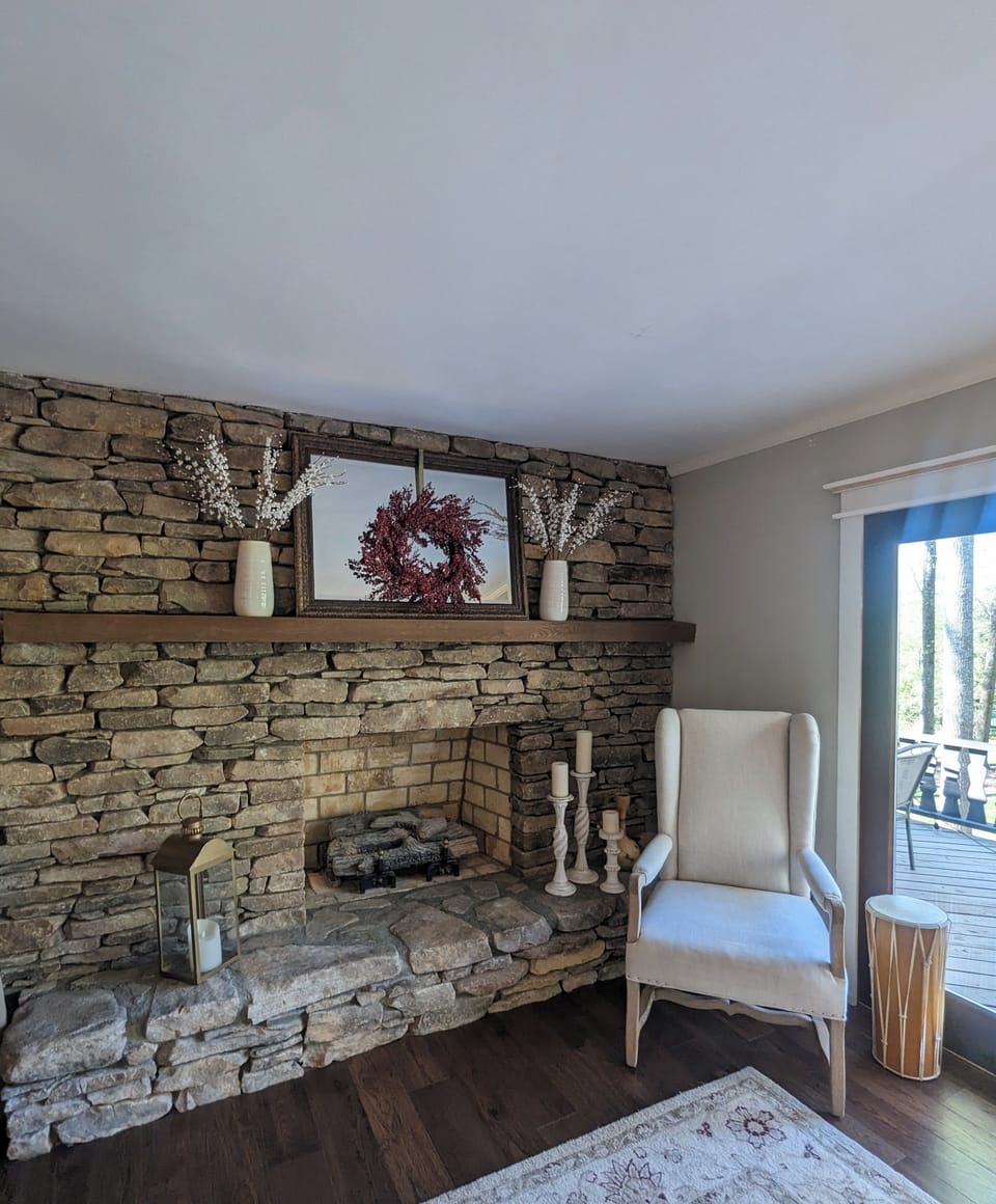 living room area with access to deck and stone fireplace 