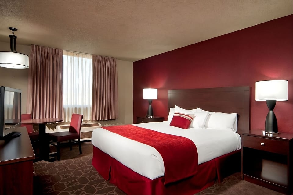 Unwind in crisp linens with a cozy workspace nearby.