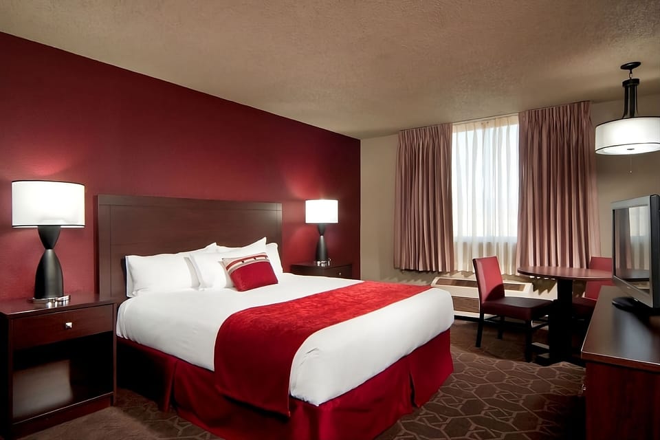 Relax in a bright king room with desk and TV.