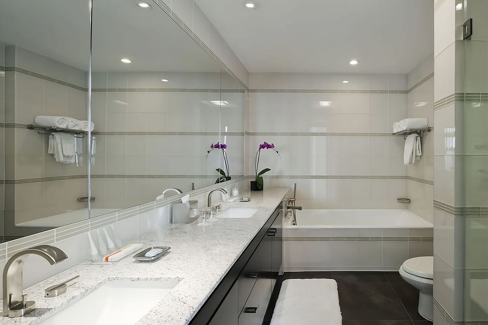 Refresh with a long vanity, bright lighting, and deep tub.