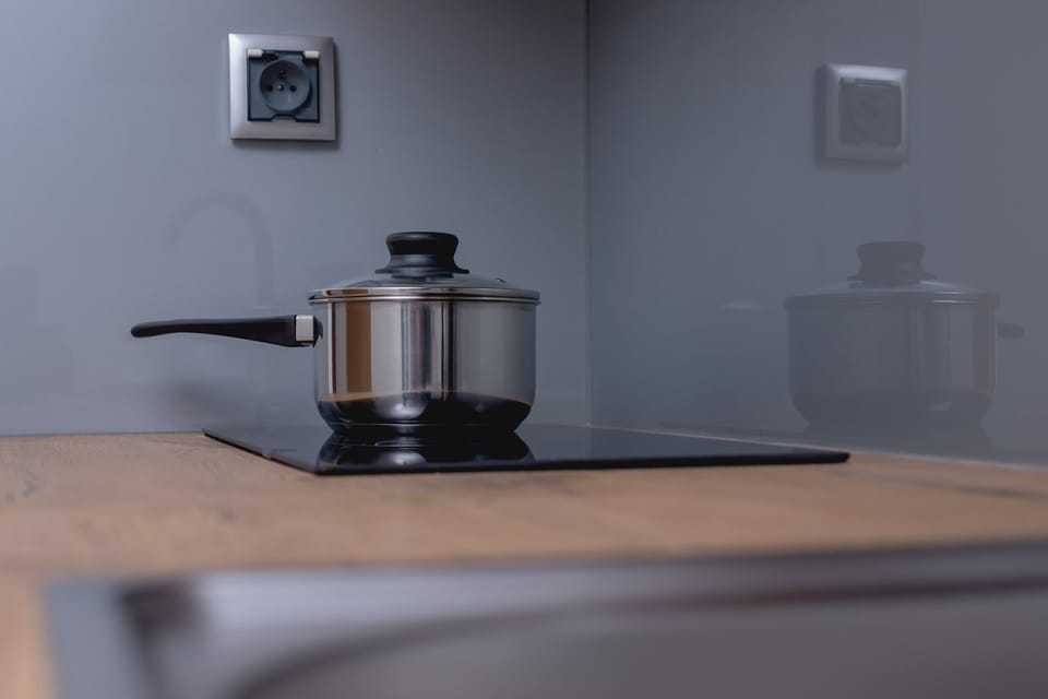 A kitchen counter with a sleek kettle and a clean minimalist design.
