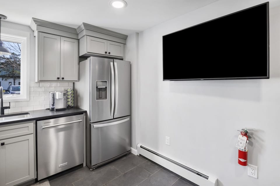 TV on kitchen wall allows bar seating for the big game