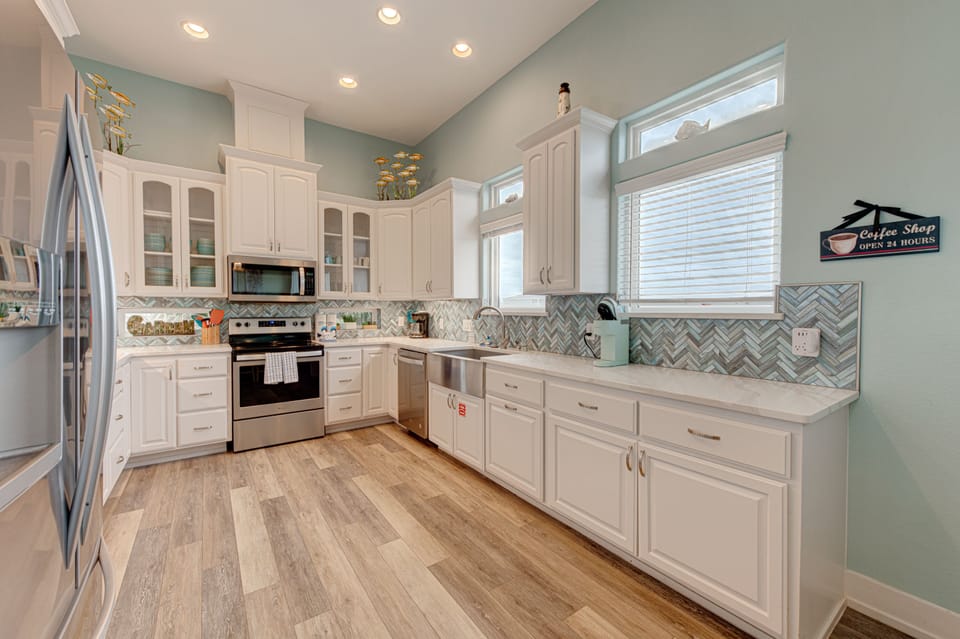 Your fully equipped kitchen features stainless steel appliances, beautiful tile backsplash, and plenty of counter space for preparing memorable meals together.