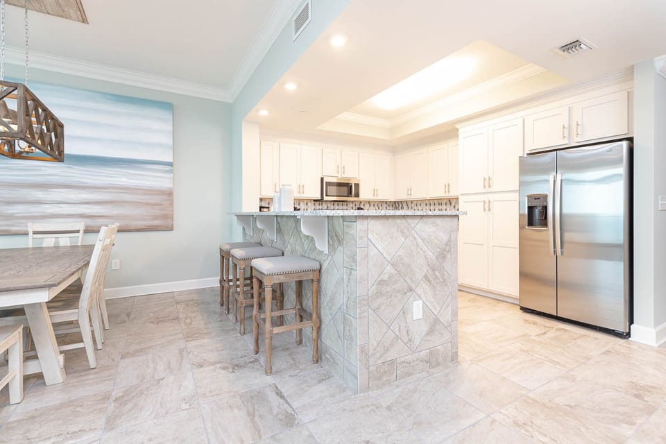 Pull up a cushioned stool at the breakfast bar and sip morning coffee in this inviting kitchen area