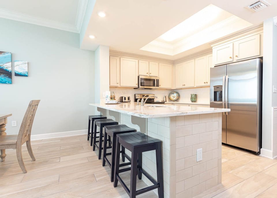 Savor your morning coffee at the breakfast bar and create memorable moments in this inviting kitchen