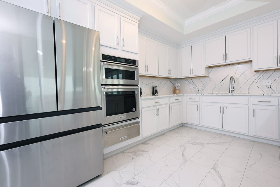 Upgrade your culinary experience in this kitchen with modern appliances and marbled accents