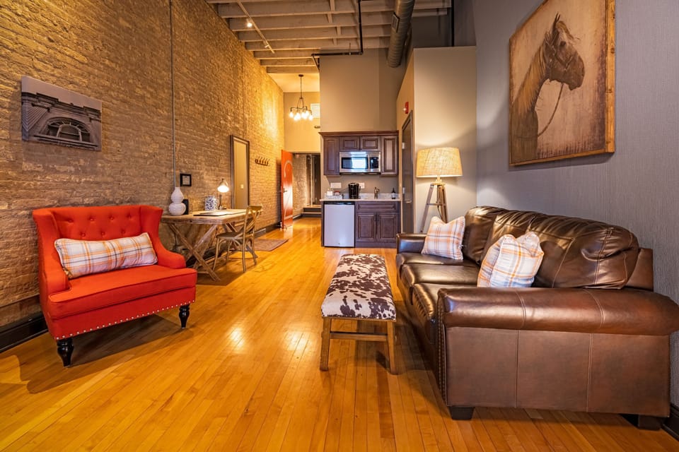 The open layout connects living, dining, and kitchen in one easy flow — all wrapped in original brick and timber ceilings.