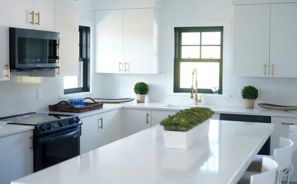 Very large open kitchen design with white quartz island and counter tops.