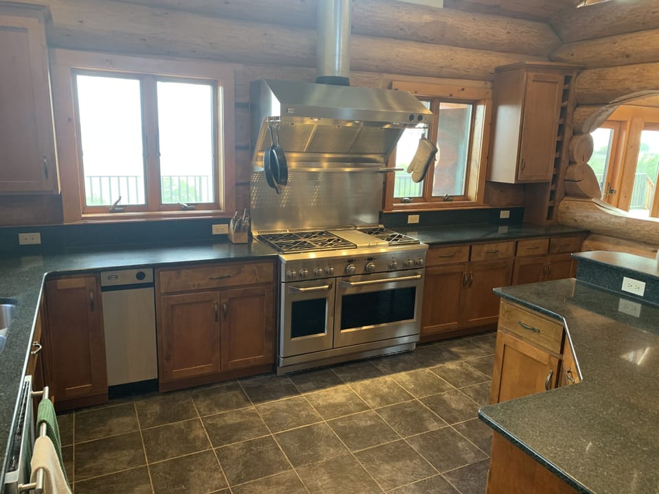 Commercial quality stove with griddle and oven. Stove has heat lamps and hood.