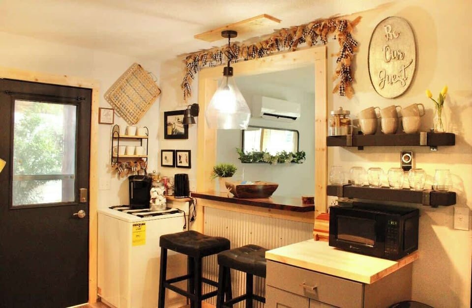 Dine at the kitchen table for two, supplemented by barstools on both sides of the pass-through window.