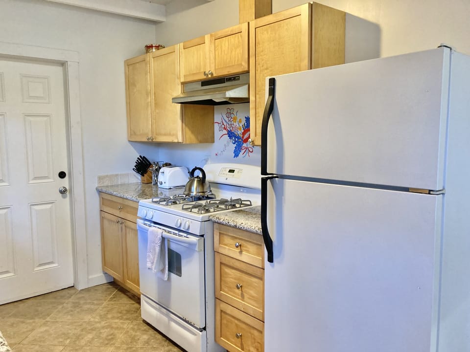 Seaglass fridge, gas stove, toaster, kettle, knives, dishes and utensils 