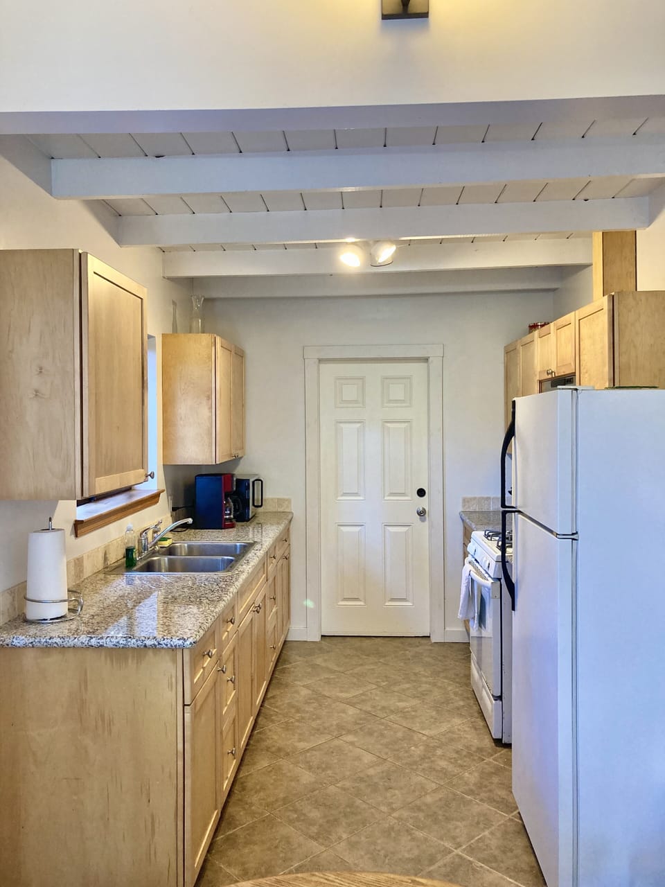 Seaglass's Well outfitted kitchen with wood cabinets and granite counters