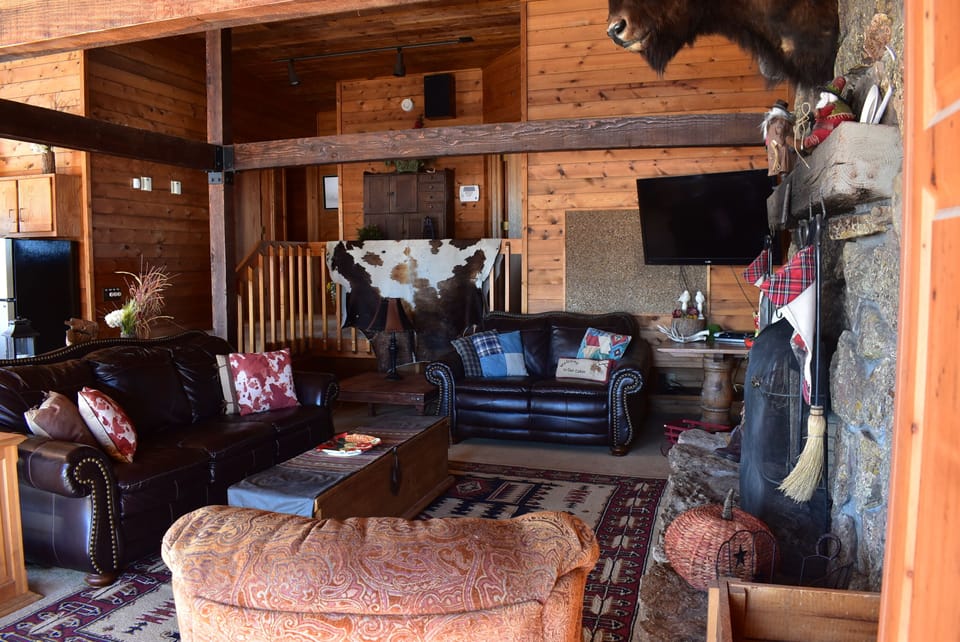 Large living room in open concept main floor with large stone fireplace