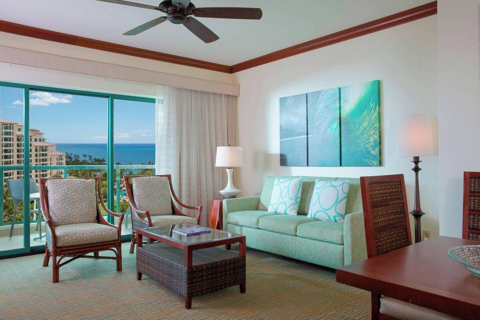 Living room features a sleeper sofa for two, TV, and floor-to-ceiling windows.