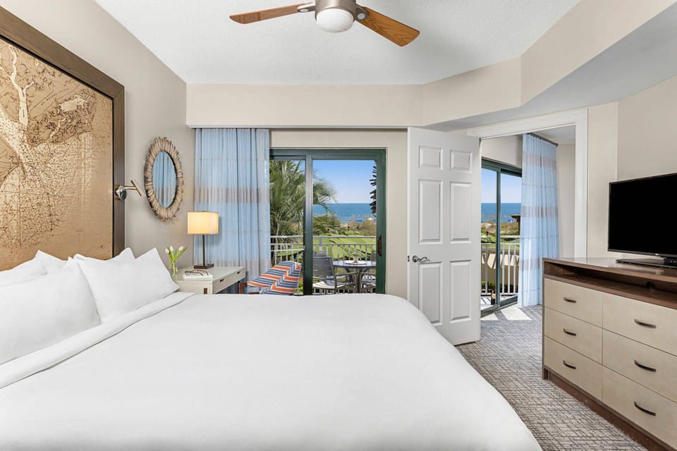 Primary bedroom features a king bed, private patio door, and ensuite bathroom (Oceanfront View)..