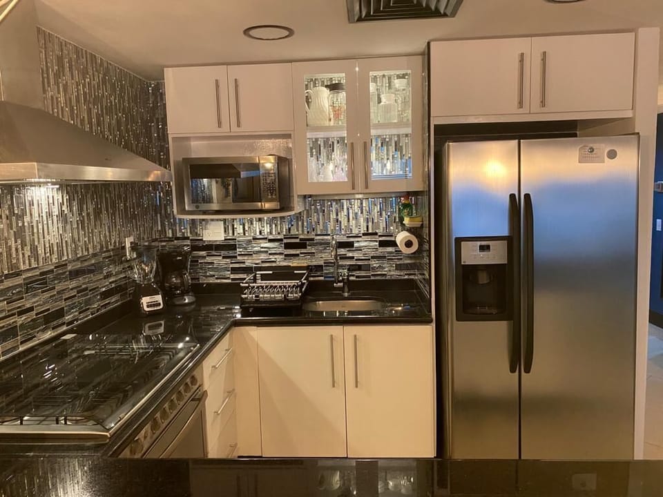 Newly remodeled kitchen with decorative glass tile and illuminated cabinets