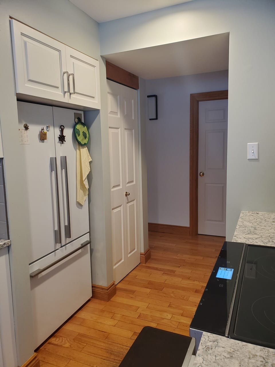 Kitchen with view of walk-in pantry, fridge and stove