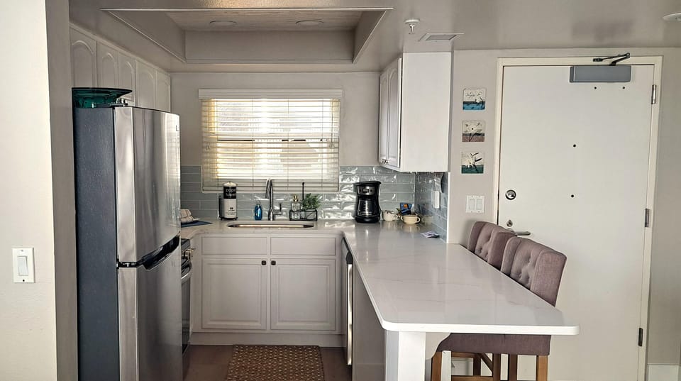 NEW-View from dining room of kitchen cabinets, counter top and appliances