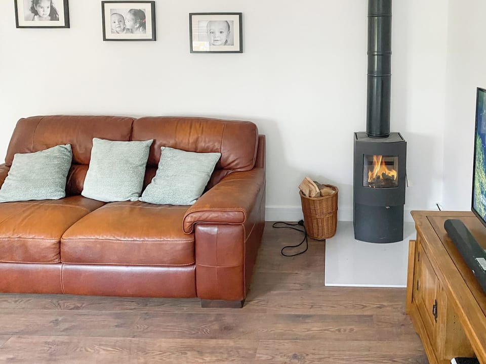 2 leather sofas and wood burner within the living area | The Cabin, Nutbourne, near Chichester