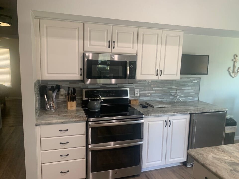 CLEAN RENOVATED KITCHEN IS FULLY STOCKED WITH ALL ESSENTIALSM AND SMART TV