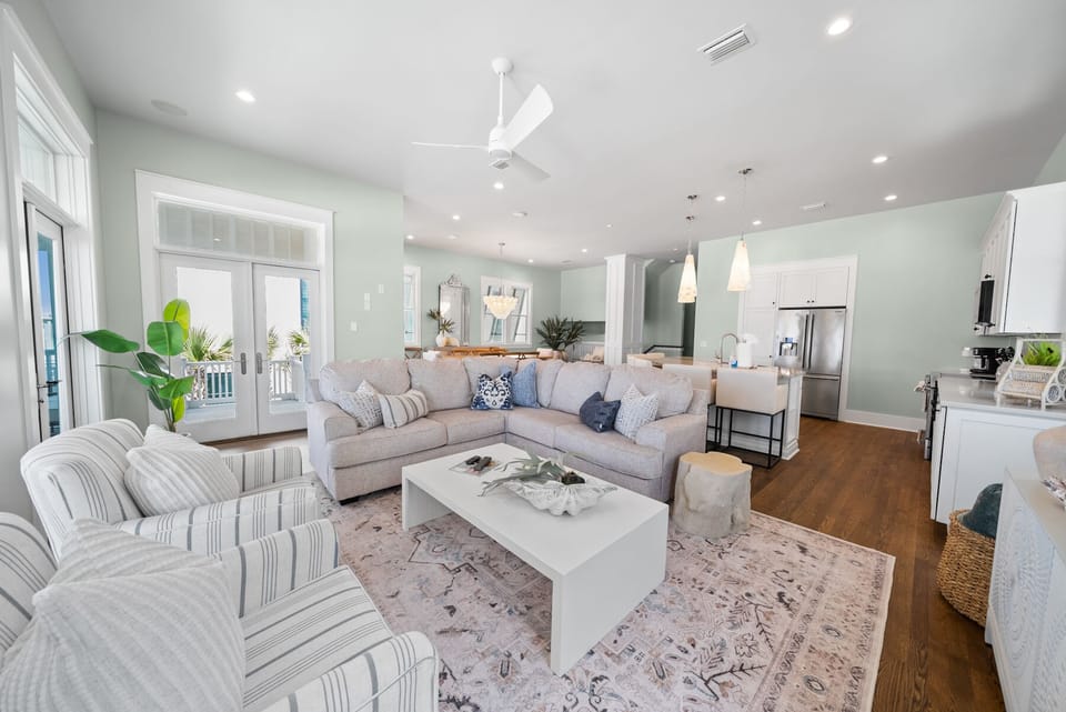 Sink into this bright, open living space where coastal comfort meets modern style with plush seating and seamless kitchen access.