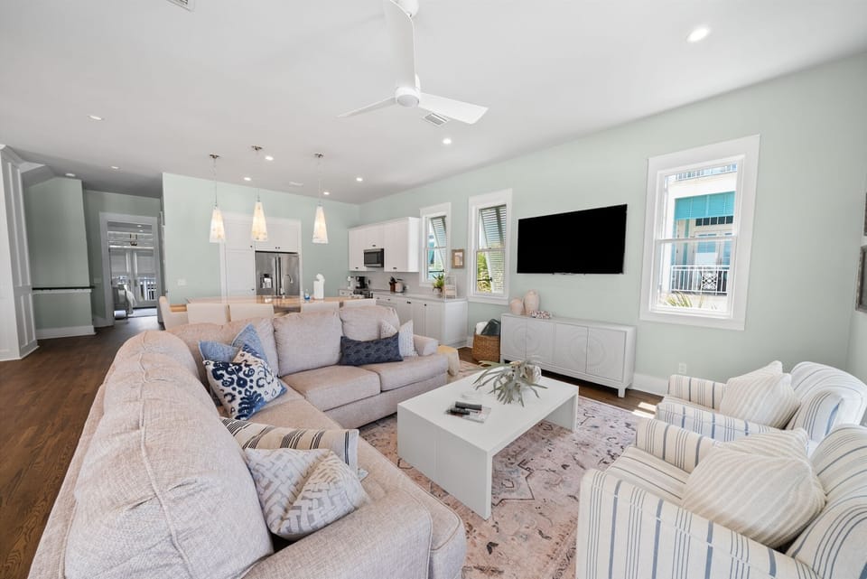 Unwind in your spacious living room featuring plush sectional seating, modern kitchen access, and entertainment center for perfect relaxation.