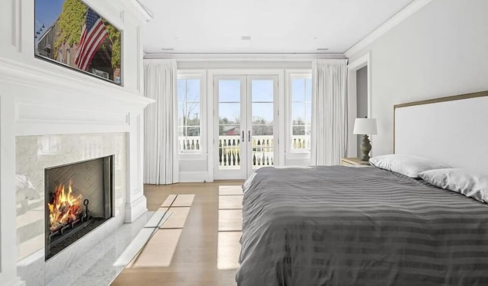 Primary Bedroom with gas fireplace and tv and terrace overlooking the pool 