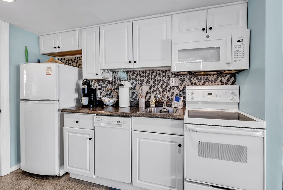 Well-stocked kitchen with full-size refrigerator, range, and built-in microwave
