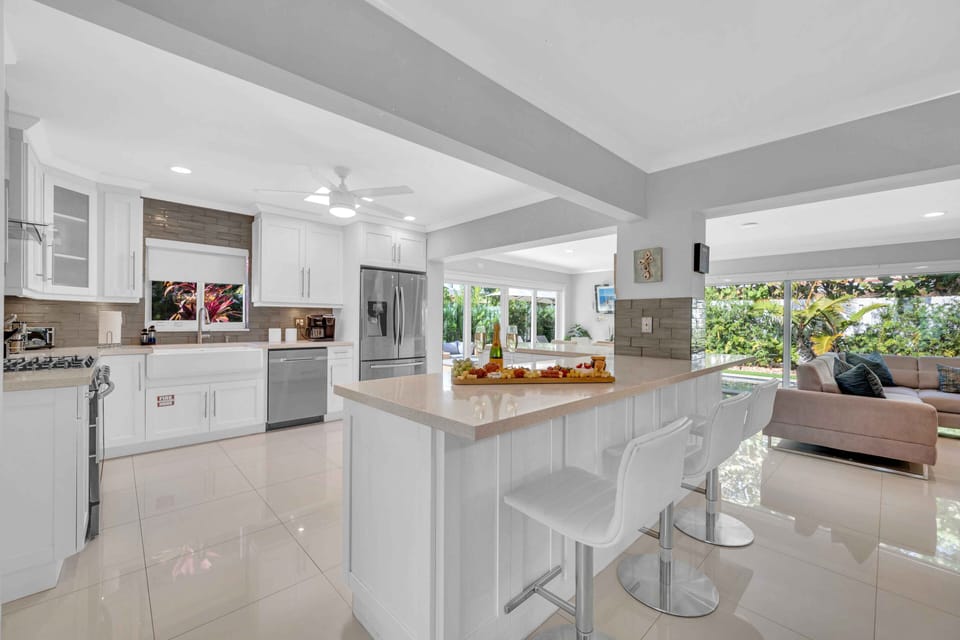 The large open kitchen is equipped with state of the art appliances for every gourmet chef. Extra counter space and a perfect view of the living room, dining room, and backyard oasis. Extra seating, featuring bar stools that seat 6.