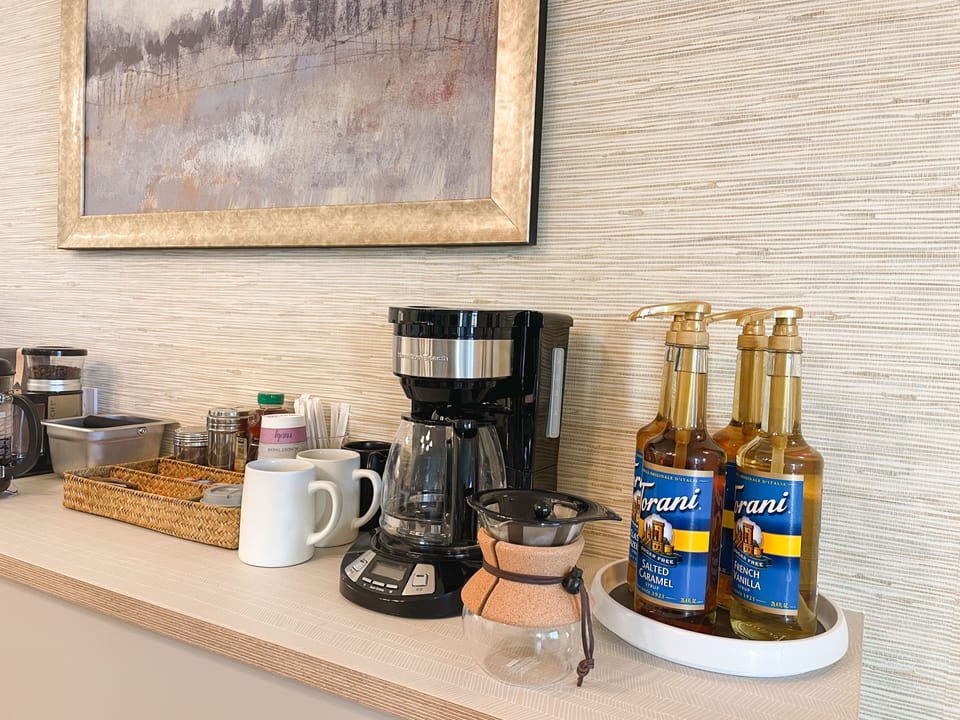 Coffee bar w/ a variety of coffees, teas, creamers, sweeteners, Torani syrups