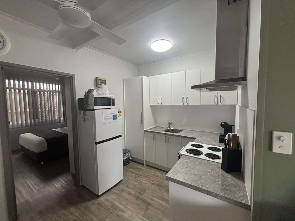 The kitchen opens onto the living area, with the second bedroom just through the doorway.