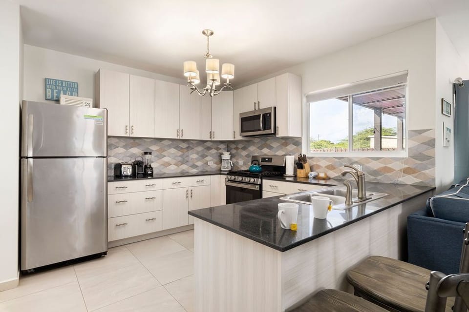 This spacious kitchen is equipped with all necessary appliances like stove, oven, coffee maker, microwave and fridge.