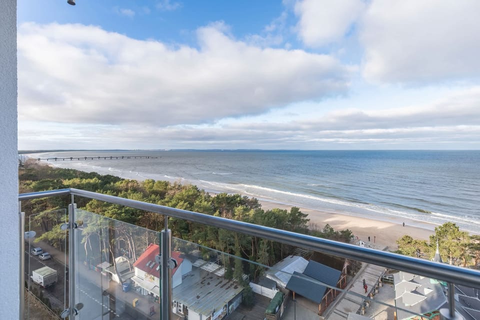 A balcony with a stunning view of the ocean and sandy beach, perfect for relaxing.
